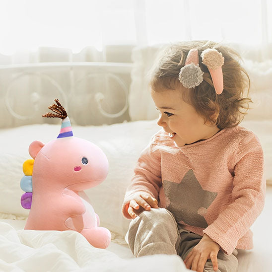 Bébé heureuse-avec-Peluche-dinosaure